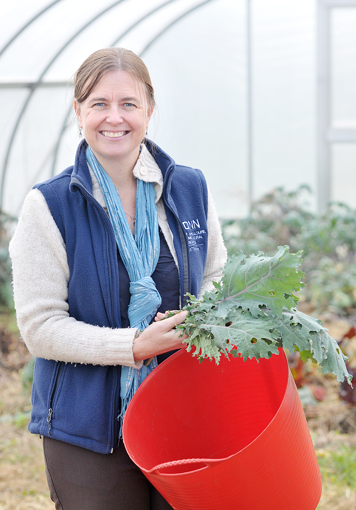 Jiff Martin smiling with a bundle of kale in her hands